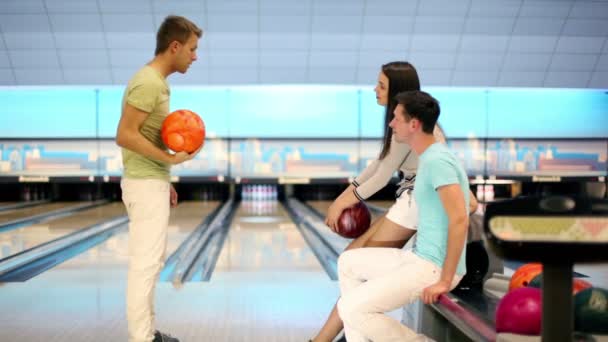 Menino com menina assistir como seu amigo joga bola de boliche — Vídeo de Stock