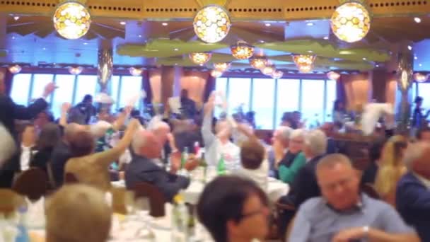 Molte persone si siedono ai tavoli e salutano scialli nel ristorante sulla nave — Video Stock