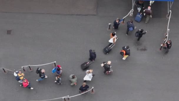 Lot of passengers walk with their luggage to entrance — Stock Video