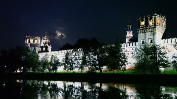 Binaların duvar aydınlatma ile novodevichy Manastırı'nın ötesinde — Stok video