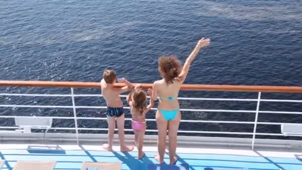 Mother, daughter and son stands waving hands on board ship — Stock Video