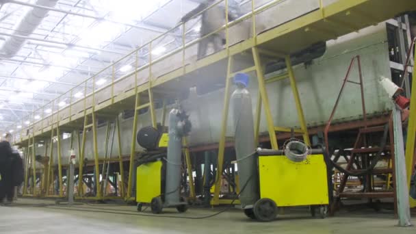 Dos cilindros con soporte de gas cerca de soldador en planta — Vídeos de Stock