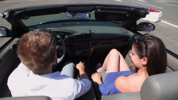 Young couple ride in cabriolet by road, behind view from above — Stock Video