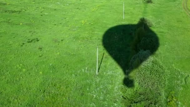 Schatten fällt auf grünem Gras vom hohen Ballon — Stockvideo
