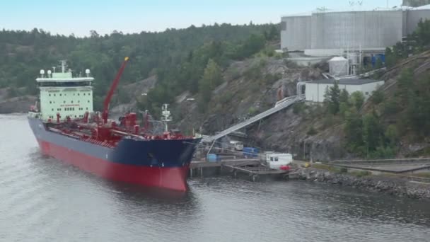 Ligplaats met industriële schip vult brandstof uit enorme opslagtank — Stockvideo