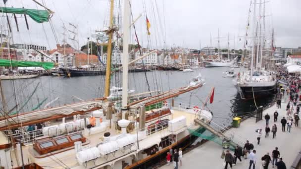 Folk går på pier nära segelfartyg som vinst på regatta — Stockvideo