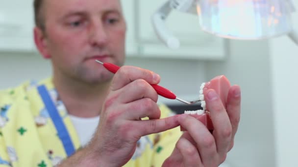 Стоматолог проверяет зубы челюсти через зеркало во время стоматологической операции — стоковое видео