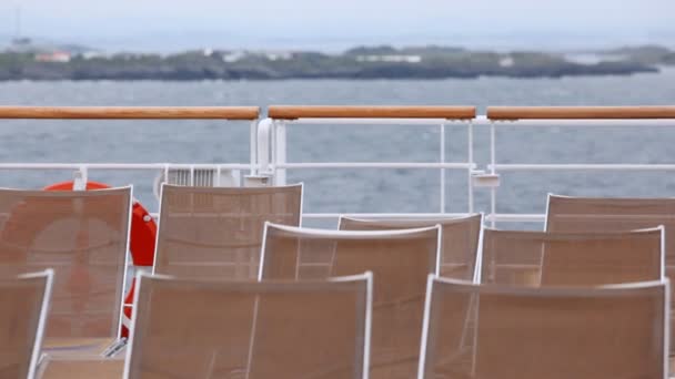 Chaise lounges staan op het schip dek tegen de hemel en de horizon — Stockvideo