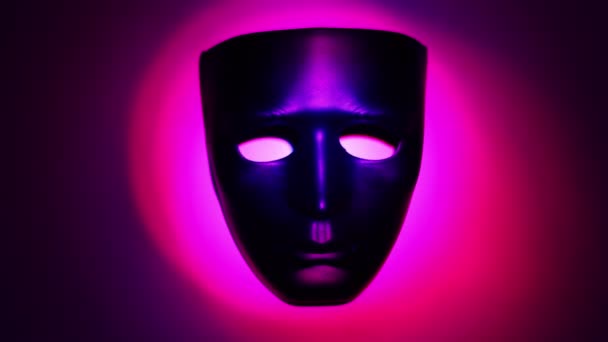 Zwarte theatrale masker in ring van licht van kleur die verandert — Stockvideo