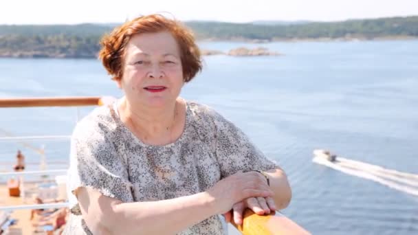 Aantrekkelijke oudere vrouw staat op het dek van het schip in de middag — Stockvideo