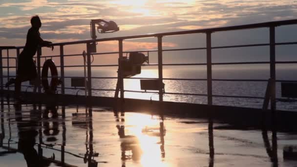 Silhouette de femme regarder coucher de soleil et s'éloigner du pont — Video