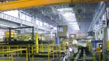 Sarı vinç yukarıdan haddehane üretim dükkanda taşır.