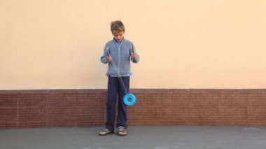 küçük çocuk iki sopa ve oyuncak duvarının yakınında oynuyor tutar