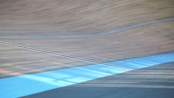 Two bicyclists ride track during race at stadium, unfocused — Stock Video