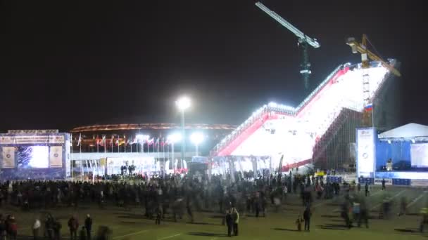 Mensen lopen in de buurt van stadium op het podium van world cup op snowboard — Stockvideo