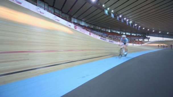 Несколько велосипедистов едут на треке во время гонки на стадионе — стоковое видео