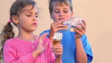 Girl and boy plays with models of tall ships in glass bottles