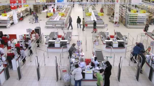 Las mujeres pagan en efectivo en los mostradores de la supertienda Auchan — Vídeos de Stock