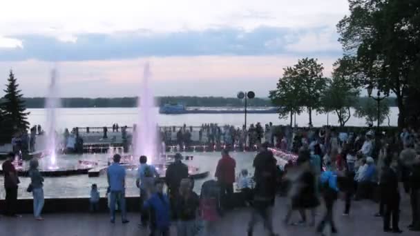 Les gens marchent avec des enfants près de la fontaine le soir — Video