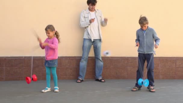 Padre e hijos niño y niña juegan juguete cerca de la pared — Vídeo de stock