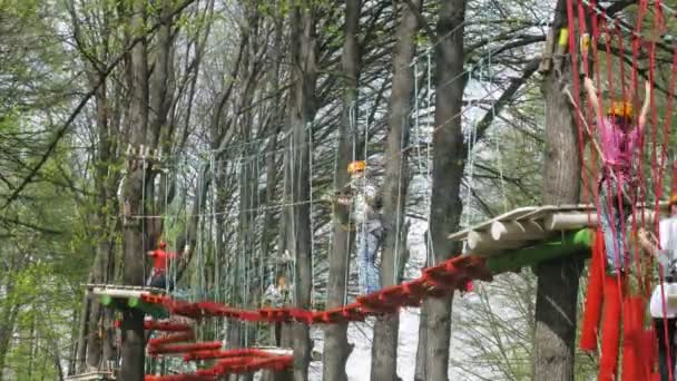 La gente va en puente de cuerda en el parque de aventuras Panda — Vídeo de stock