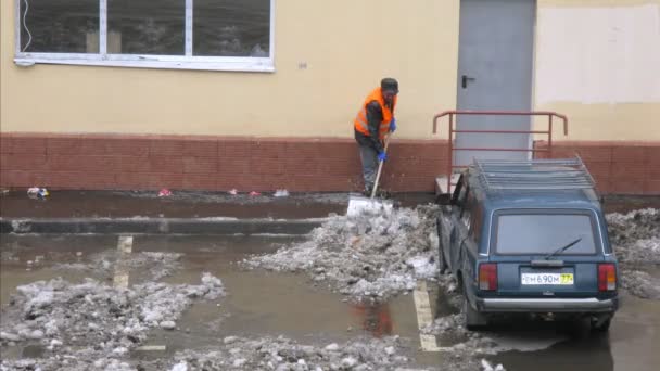 Trabajador limpia la nieve en el aparcamiento en Moscú . — Vídeos de Stock