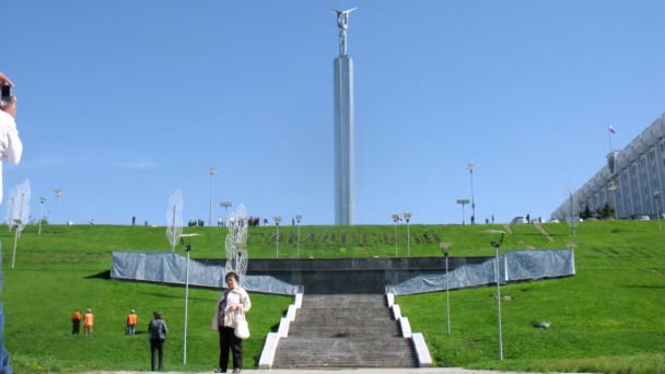 Туристи проходять повз пам'ятник слави на площі слави — стокове відео