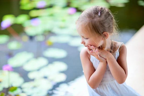 Liten flicka nära lily pond — Stockfoto