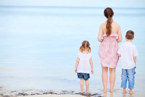 Moeder en twee kinderen op een strand — Stockfoto