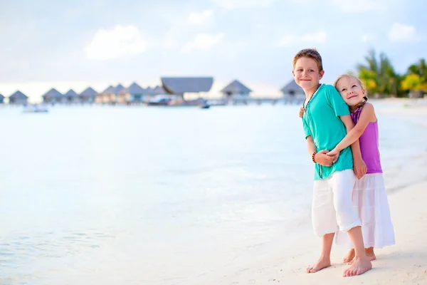 Двое детей на тропическом курортном пляже — стоковое фото