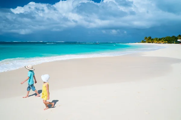 Двое детей прогуливаются по пляжу на Карибах — стоковое фото