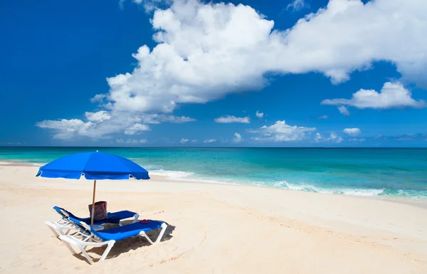 Стулья и зонтик на тропическом пляже — стоковое фото