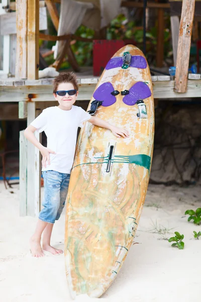Симпатичный мальчик с доской для серфинга — стоковое фото