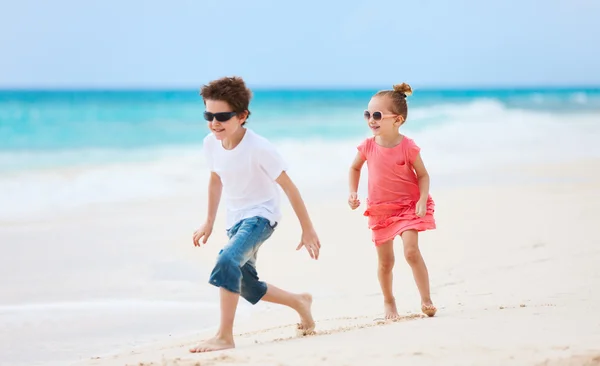 Брат и сестра прогуливаются по пляжу на Карибах — стоковое фото