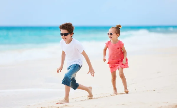 Frère et sœur marchant le long d'une plage aux Caraïbes — Photo