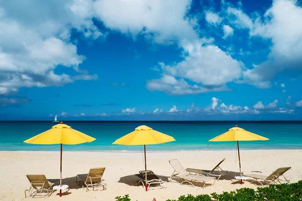 Liegestühle und Sonnenschirme an einem wunderschönen karibischen Strand — Stockfoto