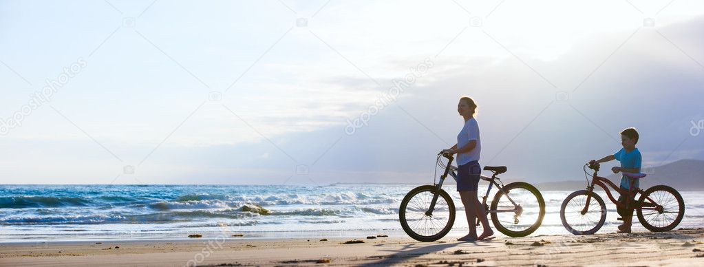 Mother and son biking at beach