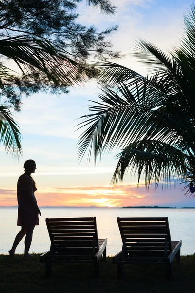 Silhouetten einer jungen Frau am Strand — Stockfoto