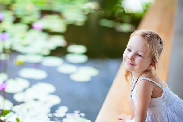 ユリの池の近くの小さな女の子 — ストック写真