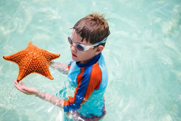 Küçük çocuk tutan dev bir deniz yıldızı — Stok fotoğraf
