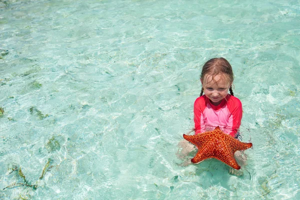 Niña con una estrella de mar —  Fotos de Stock