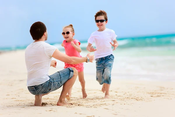 Vader en kinderen op het strand — Stockfoto