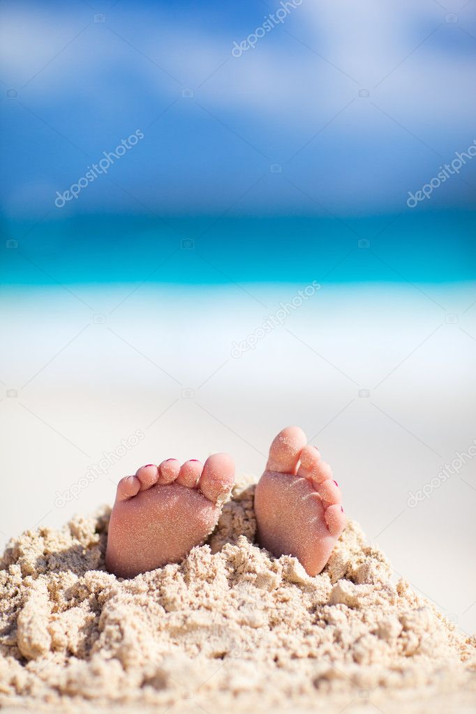 Little feet covered with sand