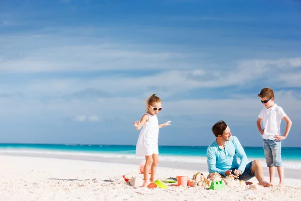 Padre con niños en la playa — Foto de Stock