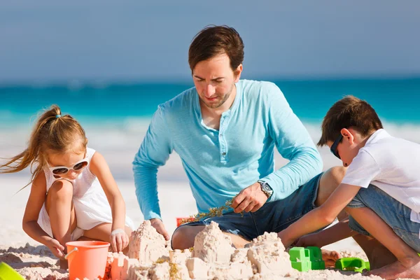 Padre con niños en la playa — Foto de Stock