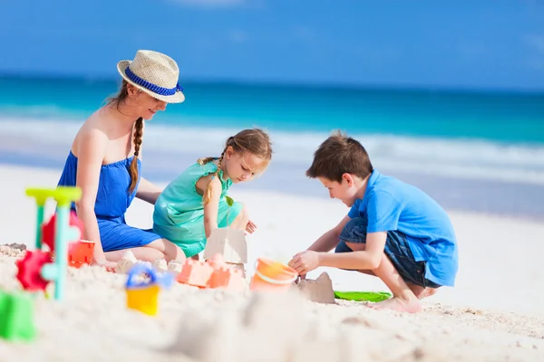 Mãe e filhos brincando na praia — Fotografia de Stock