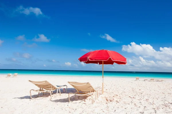 Sillas y sombrillas en una playa tropical — Foto de Stock