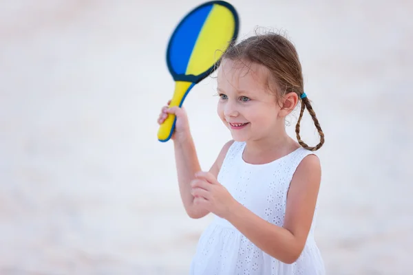 Mała dziewczynka gra tenis plażowy — Zdjęcie stockowe