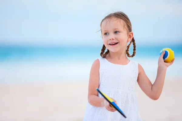 Liten jente som spiller strandtennis. – stockfoto