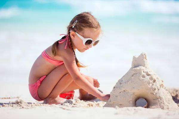 Liten flicka som leker på stranden — Stockfoto